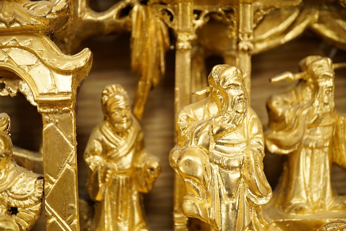 A Chinese carved gilt wood panel, depicting battle scenes, 50cm high